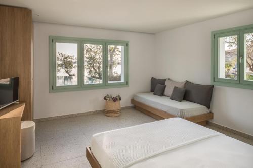 a bedroom with a bed and a couch and windows at oKEAnõs in Vourkarion