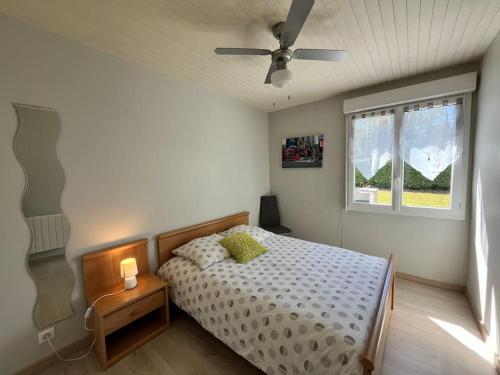 une chambre avec un lit et un ventilateur de plafond dans l'établissement La Cabane la Roma Maison cosy proche Mimizan Plage, à Mimizan