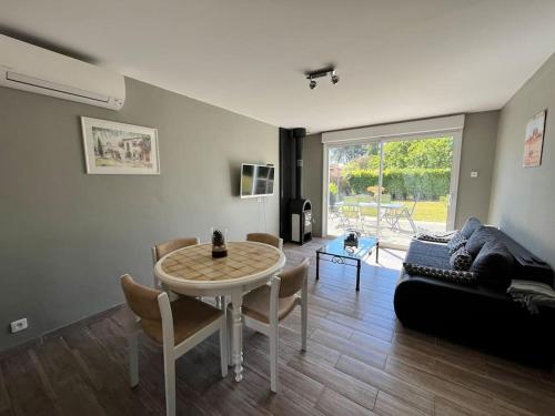 un salon avec une table et un canapé dans l'établissement La Cabane la Roma Maison cosy proche Mimizan Plage, à Mimizan