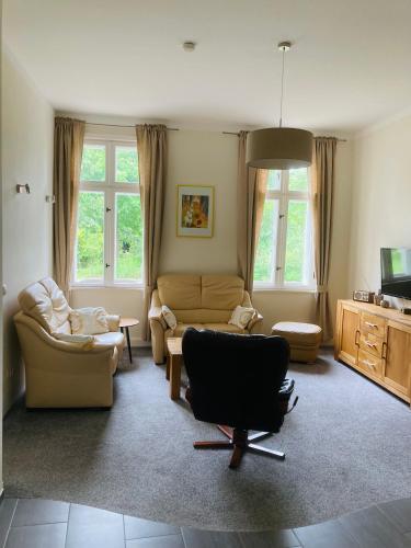 a living room with two chairs and a couch at Herrenhaus Hohewarte in Lübeck