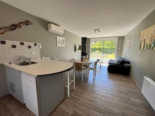 - une cuisine avec un évier et une table dans une chambre dans l'établissement La Cabane la Roma Maison cosy proche Mimizan Plage, à Mimizan