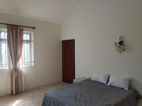 a bedroom with a bed and a window at Bamboo guest house in Quatre Bornes