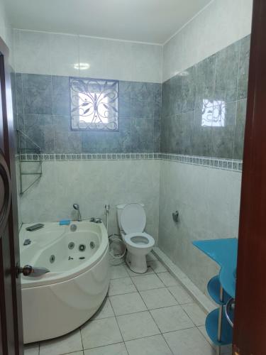 a bathroom with a tub and a toilet and a window at Bamboo guest house in Quatre Bornes