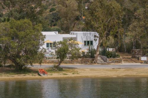 a white house on the shore of a body of water at oKEAnõs in Vourkarion