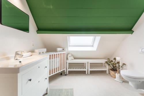 a bathroom with a crib and a green ceiling at Fall Eighteen by Romy&Travis in Bruges