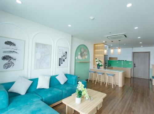 un soggiorno con divano blu e una cucina di Green Diamond Homestay Hạ Long a Ha Long