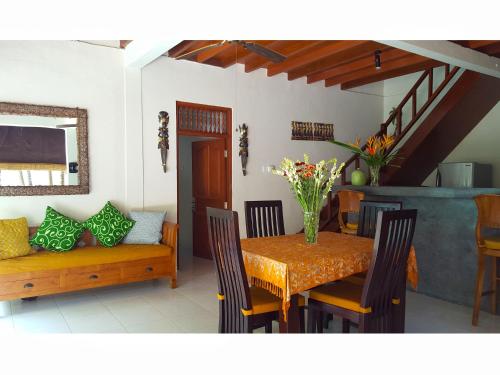 a dining room with a table and a couch at Juada Garden in Seminyak