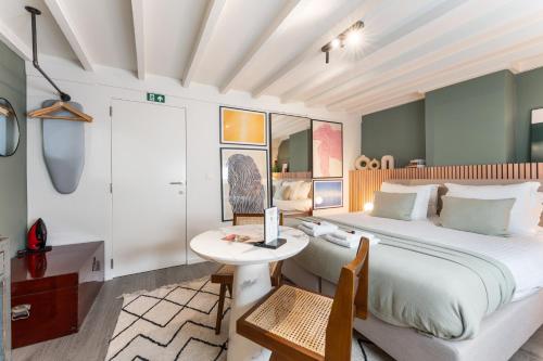 een slaapkamer met een groot bed en een tafel bij Fall Eighteen by Romy&Travis in Brugge