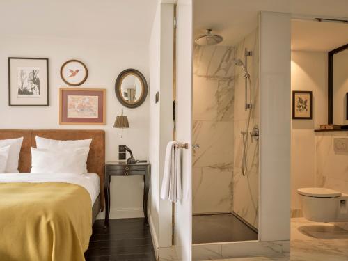 a bedroom with a bed and a shower at The Nikolai Hamburg - Leonardo Limited Edition in Hamburg