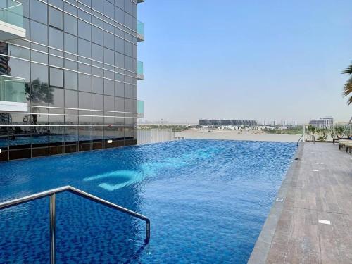 a large blue swimming pool in front of a building at AWS Homes - Modern Living in Top Location in Dubai