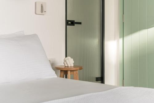 a bed with a white pillow and a small table at oKEAnõs in Vourkarion