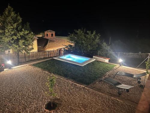 a swimming pool in the middle of a yard at night at Casita rural La cometa in Ruidera