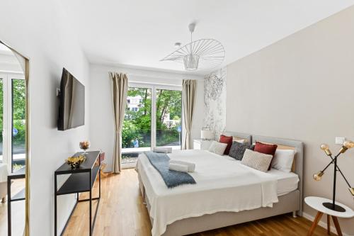 a white bedroom with a bed and a window at Sali-Homes R5 Neubau mit Terrasse im Zentrum in Bayreuth