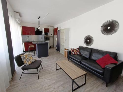 un salon avec un canapé et une table et une cuisine dans l'établissement Le Fontenoy T2 Tarbes centre ville Brauhauban, à Tarbes