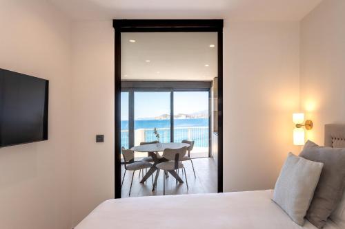 a bedroom with a bed and a table with chairs at ARENAL SUITES BENIDORM in Benidorm