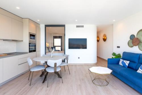 a living room with a blue couch and a table at ARENAL SUITES BENIDORM in Benidorm