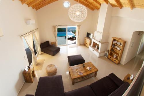 a living room with a couch and a table at Villa Asteri, Old Skala - Secluded Location - Panoramic Sea Views - Infinity Pool in Old Skala