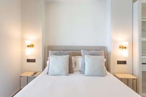 a bedroom with a large white bed with pillows at ARENAL SUITES BENIDORM in Benidorm