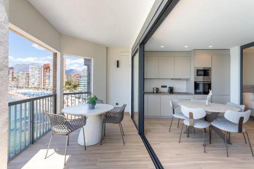 a kitchen and dining room with a balcony with tables and chairs at ARENAL SUITES BENIDORM in Benidorm