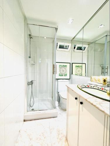a white bathroom with a shower and a toilet at Canido Beach 6 by YBH in Vigo