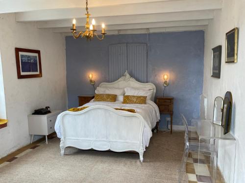 - une chambre avec un grand lit blanc et un lustre dans l'établissement Beautiful One Bedroom Cottage Near Jonzac, à Meux
