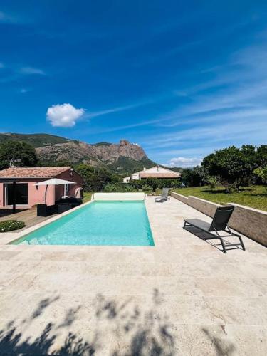 - une piscine avec une chaise à côté d'une maison dans l'établissement Charmante Villa avec Piscine, à Appietto