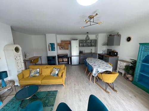 un salon avec un canapé jaune et une table dans l'établissement L'hortensia bleu, à Saint-Malo