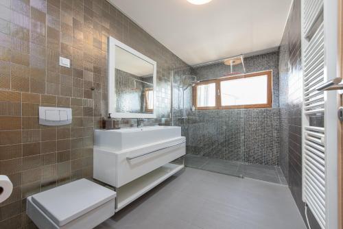 uma casa de banho com um lavatório branco e um espelho. em Villa Calla em Petrcane