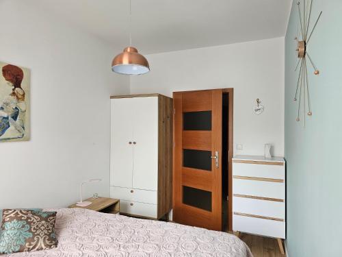 a bedroom with a bed and a wooden door at Apartament 16 - Bliżej Zdroju in Polanica-Zdrój