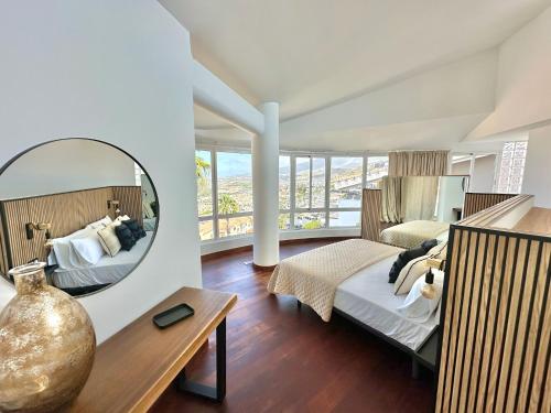 a large bedroom with a mirror and a bed at Luxury Villa Taoro private heated pool Free Car Except Christmas in Adeje