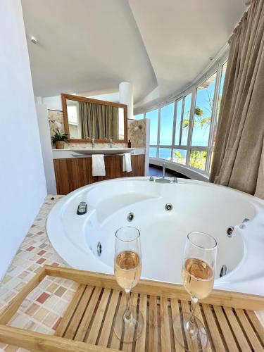 a bathroom with a tub and two glasses of wine at Luxury Villa Taoro private heated pool Free Car Except Christmas in Adeje