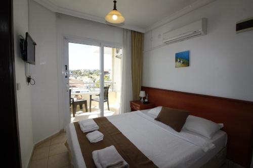 a bedroom with a large bed and a balcony at Bonapart Hotel in Çeşme