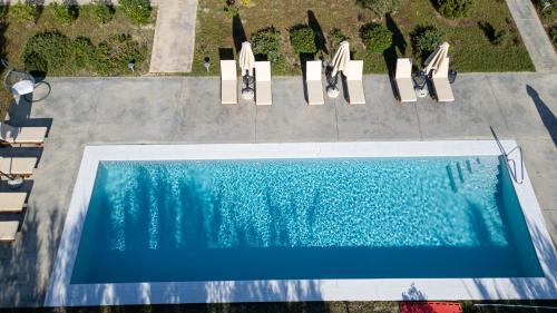 an overhead view of a swimming pool with two lounge chairs at Abeloessa Methonian Hospitality in Methoni