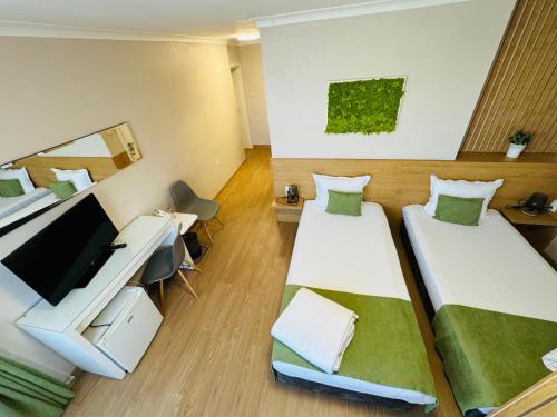 a hotel room with two beds and a tv at Hotel Amfora in St. St. Constantine and Helena