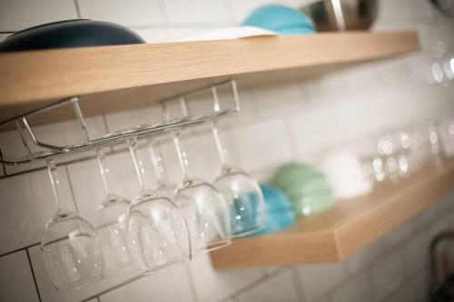 a bunch of wine glasses are hanging on a shelf at R House in Seoul