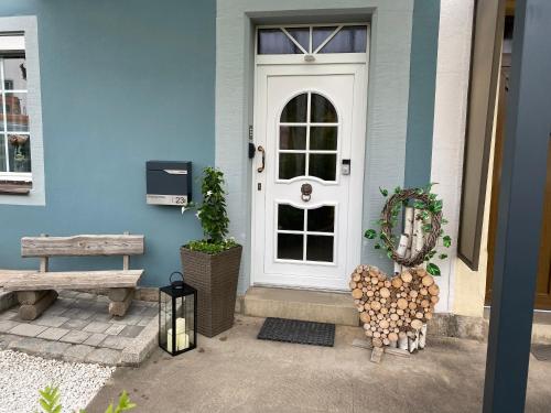 a blue house with a white door and a bench at Ferienwohnung Winkler in Rothenburg ob der Tauber