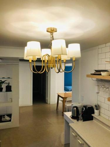a kitchen with a chandelier hanging from a ceiling at R House in Seoul