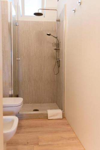 a bathroom with a shower with a toilet and a sink at Blu Sun Apartment in Complesso Riva del Sole in Giovinazzo