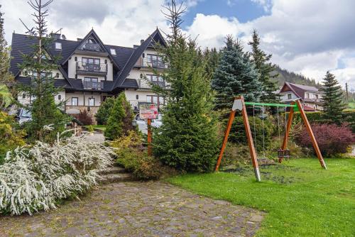 a large house with a playground in front of it at Pensjonat Litworówka Wellness&SPA in Poronin