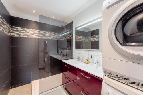 uma casa de banho com 2 lavatórios e uma máquina de lavar roupa em Appart Hypercentre CLIM 2chb QuartierChic em Aix-en-Provence