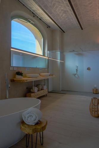 a bathroom with a tub and a sink and a mirror at Tenuta d'Arbia, Siena in Monteroni dʼArbia