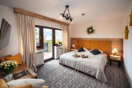 a bedroom with a bed and a large window at Pensjonat Litworówka Wellness&SPA in Poronin