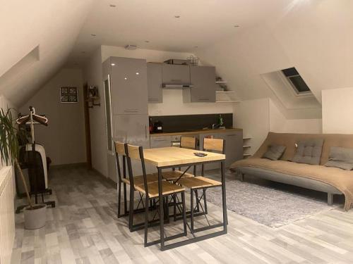 une cuisine avec une table et des chaises dans une pièce dans l'établissement Grand gîte tout confort max 24 personnes pour séminaires, anniversaire ou réunions de famille, à Mardié