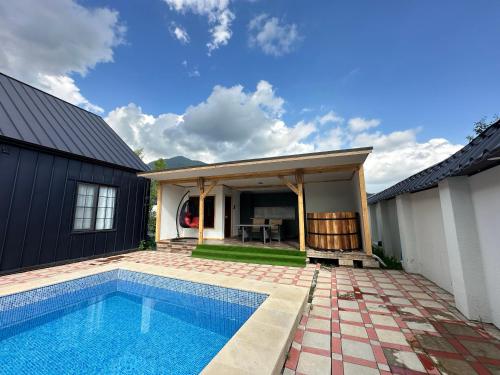 a swimming pool in front of a house at Qafqaz Suite Wood Stack in Gabala