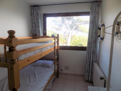 une chambre avec deux lits superposés et une fenêtre dans l'établissement Royan Pontaillac – APPARTEMENT VUE MER – balcon – WIFI – confort simple, à Royan