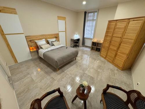 a bedroom with a bed and a table and chairs at Chambre LUXE in Quimper