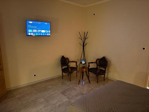 a room with two chairs and a table with a tv on the wall at Chambre LUXE in Quimper