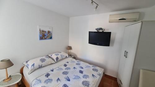 a room with a couch and a tv on the wall at Apartments Valentina Tisno in Tisno