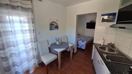 a small kitchen with a sink and a table at Apartments Valentina Tisno in Tisno