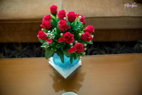 a vase filled with red roses on a table at Rehana Plaza Hotel in Cairo
